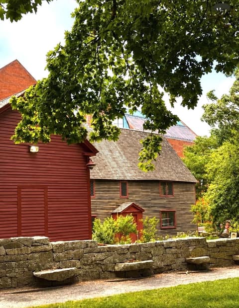 The First Period Samuel Pickman House, a weathered clapboard home (c. 1664) with diamond-paned windows, beside a red colonial building with the Peabody Essex Museum behind, Salem MA